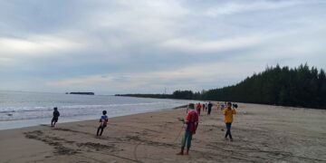 Tampak beberapa nelayan sedang menarik jala, dan pengunjung tengah mengambil foto di Pantai Tan Sridano, Senin (21/12/2020). (Genta Andalas/Fauzan Fajari)