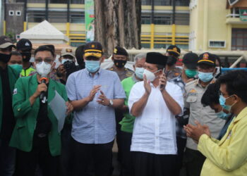 Wapresma Unand Dafiq Naskar bacakan tuntutan dalam aksi Tolak UU Cipta Kerja disaksikan oleh Kepala Disnakertrans Sumbar, Nasrizal di depan Kantor Gubernur Sumbar, Sabtu (1/5/2021). (Genta Andalas/Afdal Hasan)