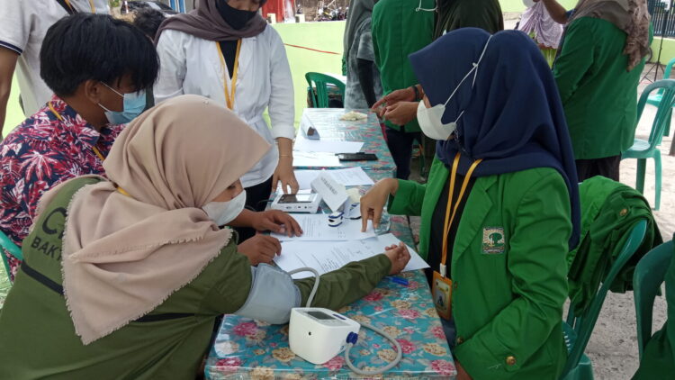 Mahasiswa KKN Unand Kelurahan Pisang melakukan pengecekan kesehatan gratis kepada masyarakat, Sabtu (21/8/2021). (Genta Andalas/Natasya Salsabilla Festy)