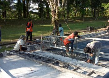 Beberapa orang pekerja sedang melakukan perbaikan jalan Gerbang-Bundaran Rektorat Unand pada Jumat (15/10/21). (Genta Andalas/ Natasya Salsabilla Festy)