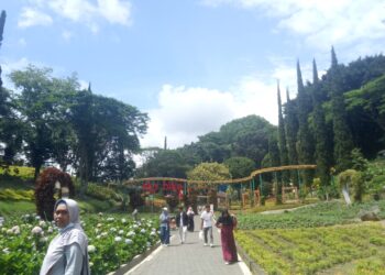 Beberapa pengunjung yang sedang berjalan dan menikmati pemandangan di Taman Selecta Malang. (Genta Andalas/Nurul Anisa Azwir)
