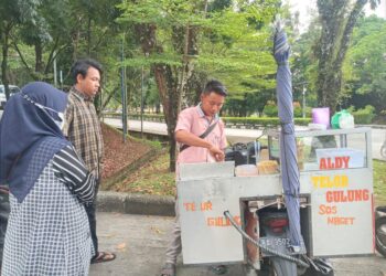 Pedagang Kaki Lima (PKL) yang sedang melayani pembeli dari kalangan mahasiswa di lingkungan bank sentral Universitas Andalas (Unand), Rabu (2/3/2022)