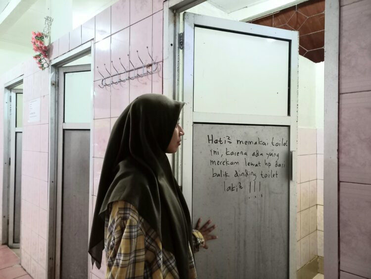 Salah seorang mahasiswi Unand memasuki toilet wanita tempat terjadinya kasus perekaman di Masjid Nurul Ilmi.