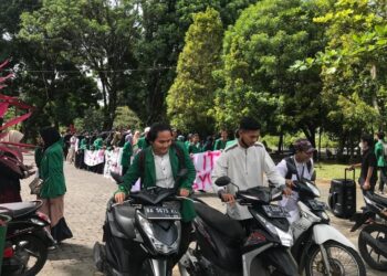 Peserta aksi mendorong beberapa motor dari Masjid Nurul Ilmi ke Rektorat sebagai bentuk protes atas banyaknya kasus kehilangan motor di Unand, pada Jumat (14/10/2022) (Genta Andalas/Nabila Annisa)