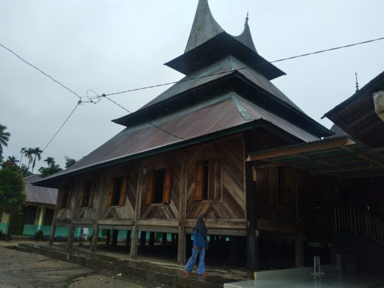 Seorang pengunjung berdiri di samping Surau Gadang Syekh Burhanaddin, Nagari Tanjung Medan, Ulakan, Kabupaten Padangpariaman, Sumatra Barat, pada Minggu (13/11/2022) (Genta Andalas/Souty) 