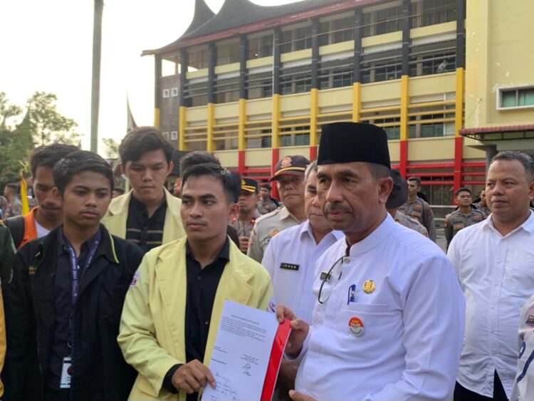 Kepala Dinas Pendidikan Sumbar, Barlius bersama  aliansi BEM Sumbar saat penandatanganan tuntutan aksi di depan kantor Gubernur Sumbar pada Jumat (25/11/2022). (Genta Andalas/ Kerina Jefani)
