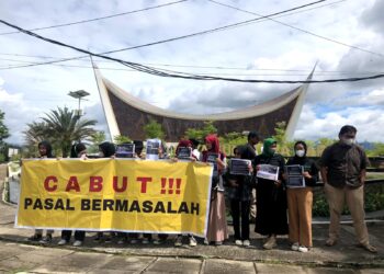 Aksi unjuk rasa  digelar oleh Aliansi Jurnalis Indonesia (AJI) Sumatra Barat dan Pers Mahasiswa yang menentang pengesahan pasal-pasal RKUHP yang dinilai mengancam kebebasan pers, di depan Masjid Raya Sumbar pada Senin (5/12/2022). (Genta Andalas/ Putri Salsabila Eryadi)