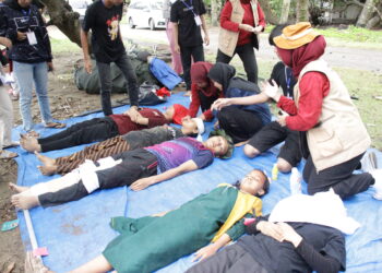 Peserta kader melakukan simulasi penanganan pasca bencana gempa bumi dan tsunami bersama mahasiswa Program Studi Profesi/Ners Fakultas Keperawatan Unand di Pantai Kampung KB, Parupuk Tabing, Padang pada Jumat (2/12/2022). (Genta Andalas/Fatiza Khaira)