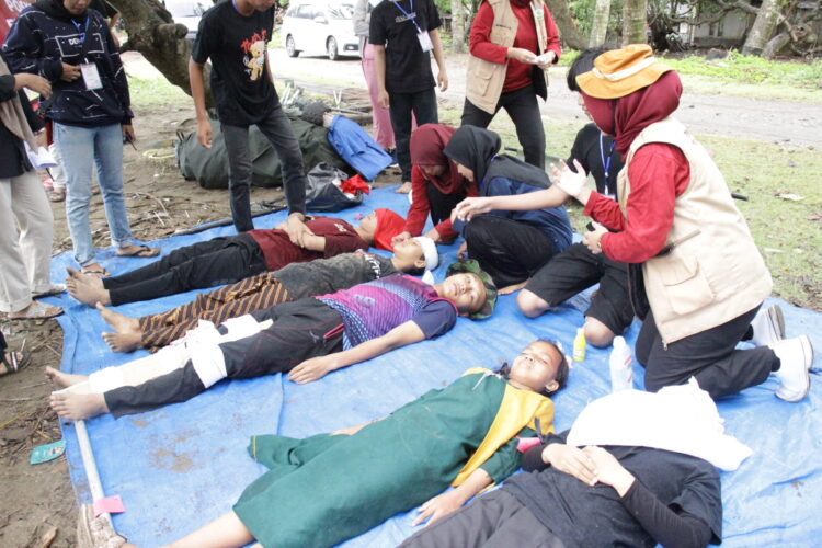 Peserta kader melakukan simulasi penanganan pasca bencana gempa bumi dan tsunami bersama mahasiswa Program Studi Profesi/Ners Fakultas Keperawatan Unand di Pantai Kampung KB, Parupuk Tabing, Padang pada Jumat (2/12/2022). (Genta Andalas/Fatiza Khaira)