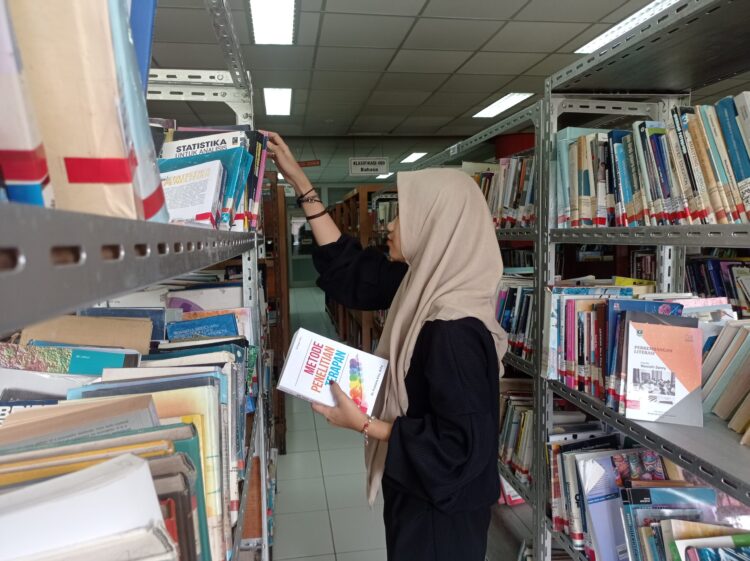 Potret Mahasiswa sedang Memilih Koleksi Buku di Lantai II Perpustakaan Universitas Andalas, Selasa (29/03/2022). (Genta Andalas/ Joy Prima)