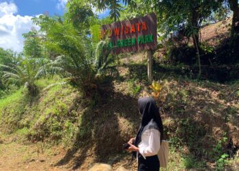 Seorang pengunjung saat hendak memasuki wilayah Ekowisata Sungkai Green Park, Selasa (27/6/2023) (Genta Andalas/Vannisa Fitri)