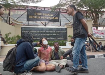 Mahasiswa yang dijadikan contoh bentuk penyiksaan oleh aparat kepolisian yang dipaksa untuk mengaku atas perbuatannya dalam menyuarakan suara rakyat di depan kantor Polda Sumbar, Senin (26/6/2023) (Genta Andalas/Fahara Azzah Syafaqoh)