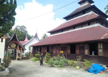 Seorang pengunjung sedang melihat keunikan Masjid Kurang Aso 60, Jumat (30/6/2023) (Genta Andalas/Vannisa Fitri)