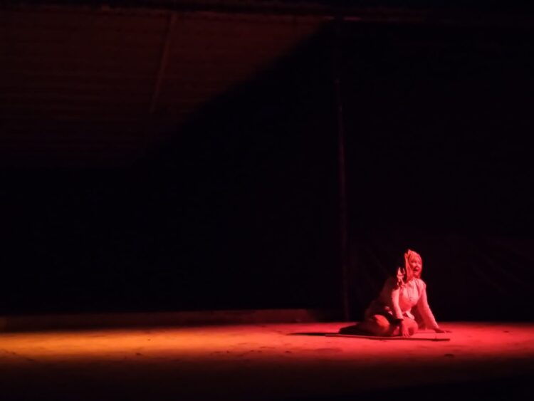 Ibu Malin Kundang pada pementasan drama "Malin Kundang" tampil berdoa mengharap petunjuk Tuhan bahwa pria muda dan gagah itu adalah sang anak di Medan Nan Balinduang FIB UNAND pada Minggu (2/7/2023). (Genta Andalas/Fahara Azzah Syafaqoh)