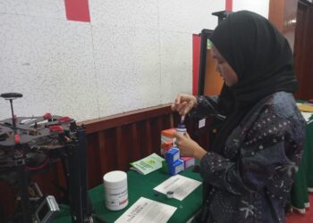 Salah seorang pengunjung yang mencoba inovasi tinta organik dari gambir pada acara Dies Natalis UNAND di Convention Hall UNAND pada Rabu (13/09/2023). (Genta Andalas/Atika Liutami Sadri)