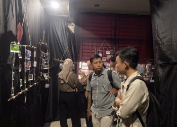 Para pengunjung sedang melihat berbagai foto yang dipamerkan  (Genta Andalas/Nabila Annisa)