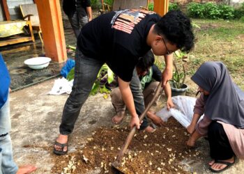Proses pencampuran bahan baku pupuk organik kotoran ayam petelur dengan cairan EM4 (Dok.Pribadi)