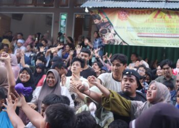 Momen masyarakat yang hadir berebut gula yang di"serakkan" dari atap masjid dalam tradisi Serak Gulo, Minggu (1/12/2024)