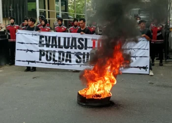 Massa aksi evaluasi 100 hari kerja Kepala Kepolisian Daerah Sumatera Barat melakukan demonstrasi membakar ban di depan kantor Polda Sumbar, pada Senin (21/4/2025) ( Oktavia Ramadhani)