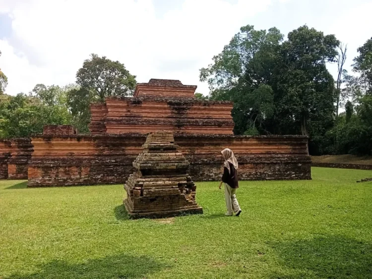 Seorang pengunjung menyusuri kawasan Candi Tinggi di Kompleks Candi Muaro Jambi, salah satu situs peninggalan Buddha terbesar di Asia Tenggara, Sabtu (19/7/2025) (Genta Andalas/Auryn Dzakirah)