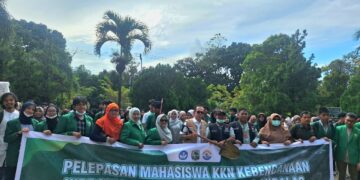 Foto bersama dan penyerahan peralatan KKN dari Rektor UNAND, Efa Yonnedi kepada lurah daerah sasaran KKN Kebencanaan di Lapangan PKM UNAND pada Jumat (5/12/2025) (Genta Andalas/Tantri Pramudita)