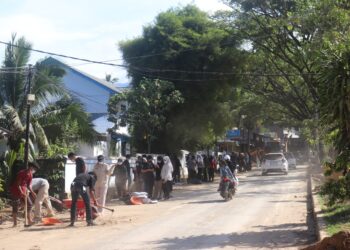 Terlihat mahasiswa KKN Kebencanaan UNAND memadati Jalan Simpang Pasia, untuk membersihkan sisa lumpur dan sampah pascabanjir Sabtu (6/12/2025) (Genta Andalas/Pitri Yani)