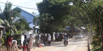 Terlihat mahasiswa KKN Kebencanaan UNAND memadati Jalan Simpang Pasia, untuk membersihkan sisa lumpur dan sampah pascabanjir Sabtu (6/12/2025) (Genta Andalas/Pitri Yani)