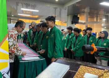 Ketua Organisasi Mahasiswa (Ormawa) Universitas Andalas menandatangani Surat Keputusan (SK) di hadapan Rektor dalam prosesi pelantikan kepengurusan Ormawa di Universitas Andalas, Kamis (5/3/2026) (Genta Andalas/Pitri Yani).