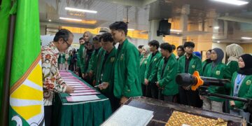 Ketua Organisasi Mahasiswa (Ormawa) Universitas Andalas menandatangani Surat Keputusan (SK) di hadapan Rektor dalam prosesi pelantikan kepengurusan Ormawa di Universitas Andalas, Kamis (5/3/2026) (Genta Andalas/Pitri Yani).