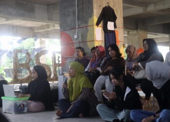 Seorang peserta menyampaikan pendapat dalam sesi Diskusi Publik International Women’s Day di Gedung Terbengkalai Taman Budaya Sumbar, Jumat (13/3/2026) (Genta Andalas/Oktavia Ramadhani)