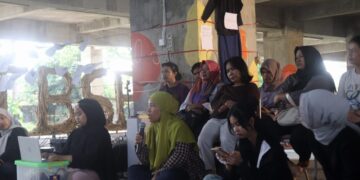 Seorang peserta menyampaikan pendapat dalam sesi Diskusi Publik International Women’s Day di Gedung Terbengkalai Taman Budaya Sumbar, Jumat (13/3/2026) (Genta Andalas/Oktavia Ramadhani)