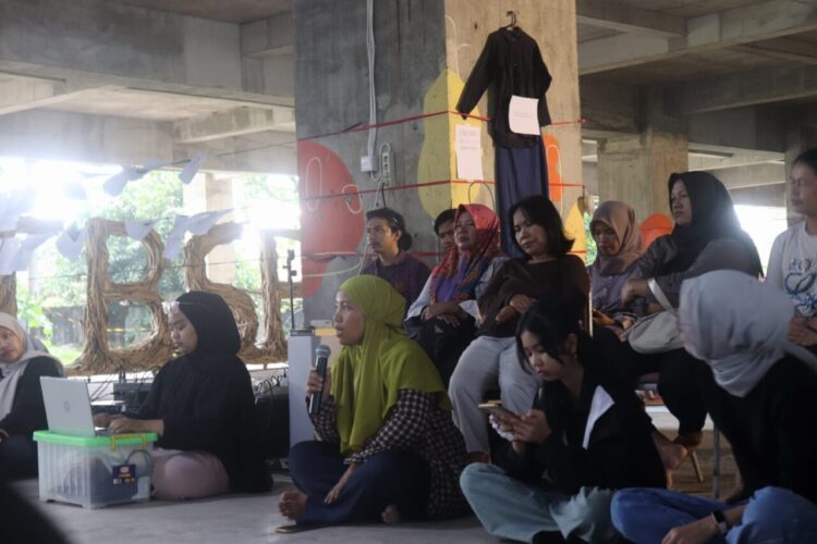 Seorang peserta menyampaikan pendapat dalam sesi Diskusi Publik International Women’s Day di Gedung Terbengkalai Taman Budaya Sumbar, Jumat (13/3/2026) (Genta Andalas/Oktavia Ramadhani)