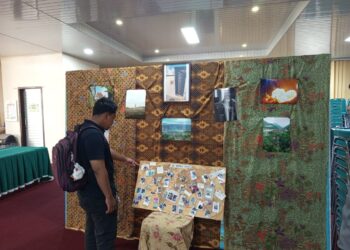 Seorang pengunjung melihat karya fotografi yang ditampilkan pada Selasa(2/6/2026) (Genta Andalas/Nabila Ramadani)
