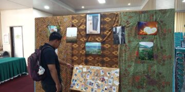 Seorang pengunjung melihat karya fotografi yang ditampilkan pada Selasa(2/6/2026) (Genta Andalas/Nabila Ramadani)