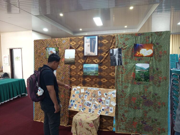 Seorang pengunjung melihat karya fotografi yang ditampilkan pada Selasa(2/6/2026) (Genta Andalas/Nabila Ramadani)